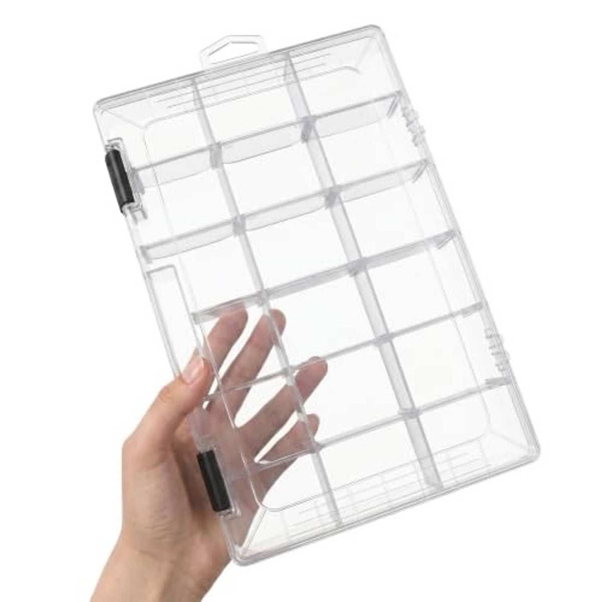 Clear tackle box held open by a hand, showing grid dividers