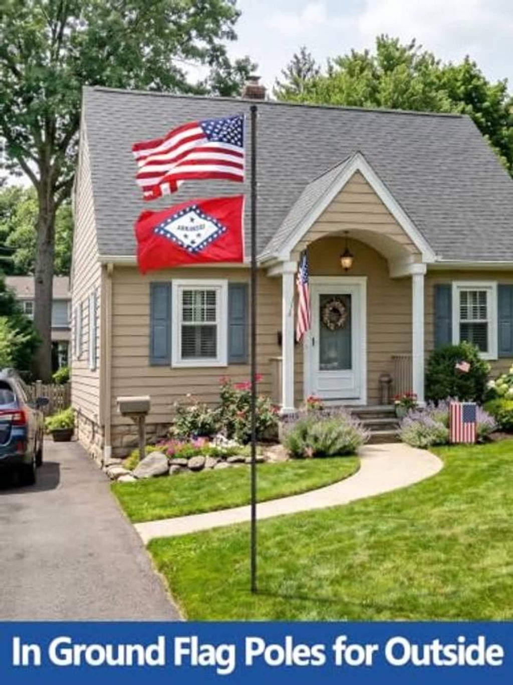 Black in-ground flag pole with American flags outside a house on a lawn