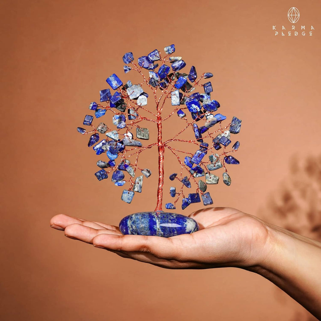 Lapis lazuli stone tree held in hand, blue chips on red copper wire with oval base