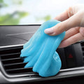 Blue cleaning gel putty held above car vent grille