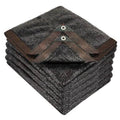 Black mesh shade cloth with reinforced corner grommets and tie loops, neatly stacked