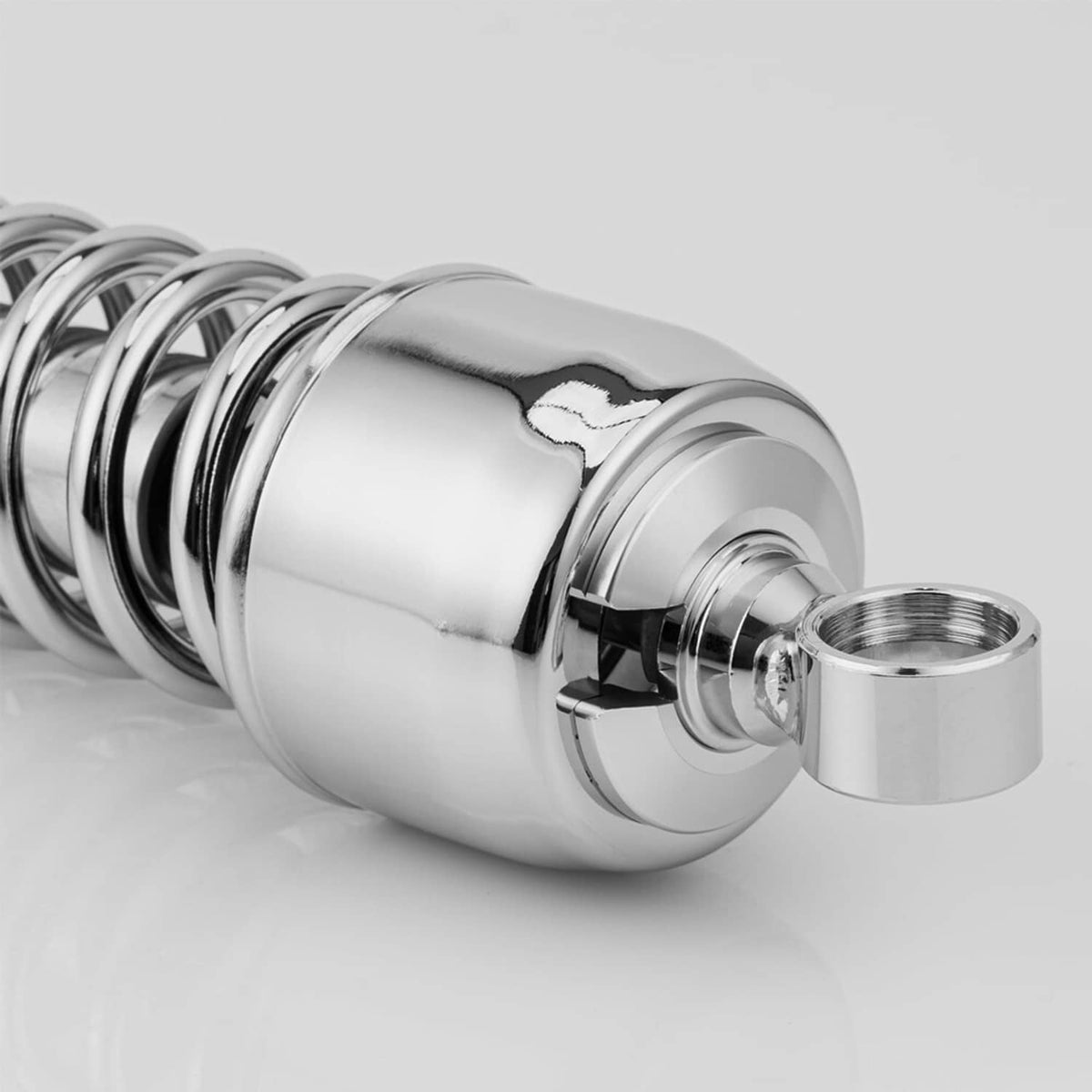 Chrome rear shock absorber with coiled spring and threaded mounting stud close-up