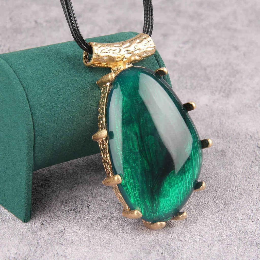 Green teardrop pendant necklace with gold accents on black faux leather cord