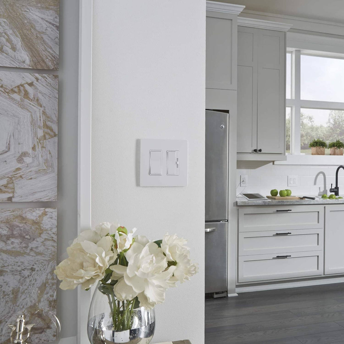 White decorator rocker dimmer switch on wall with outlet beside it