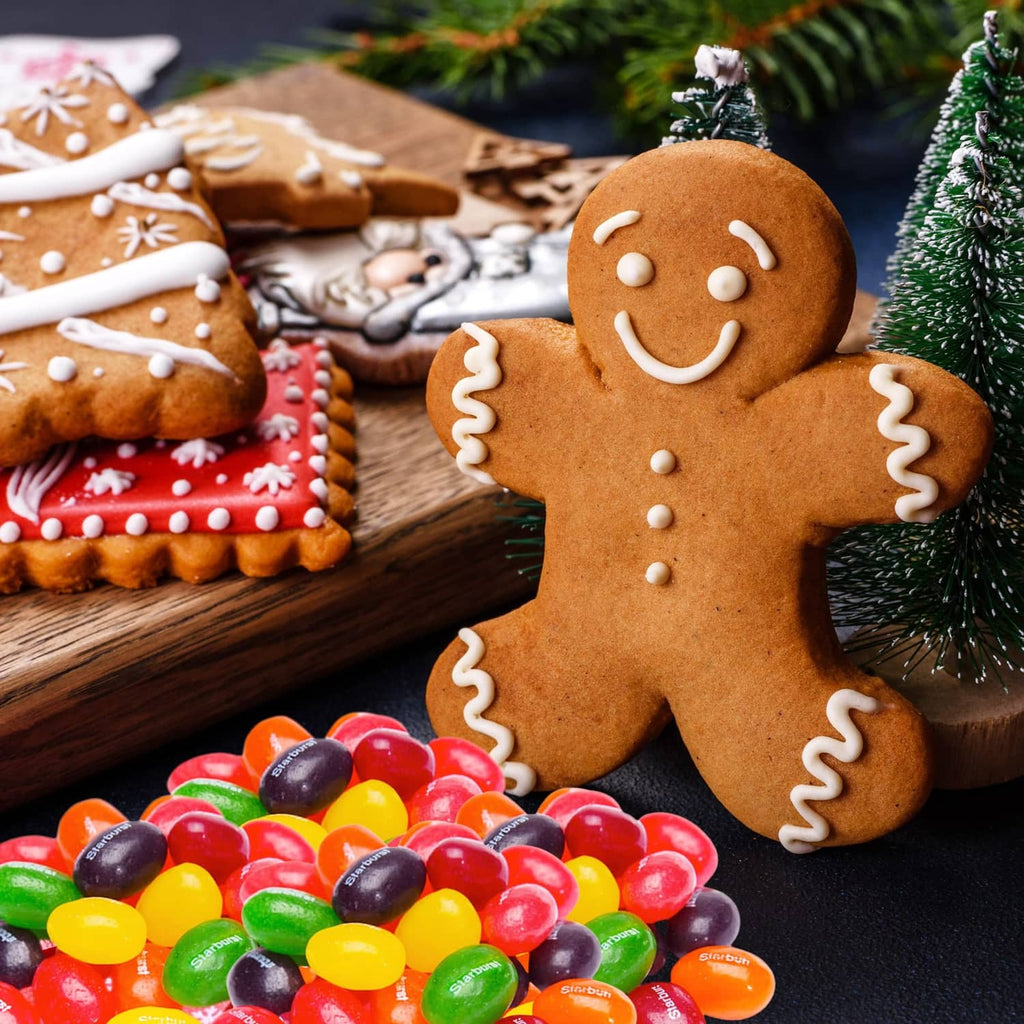 Jelly beans in a pile beside gingerbread cookies and festive greenery