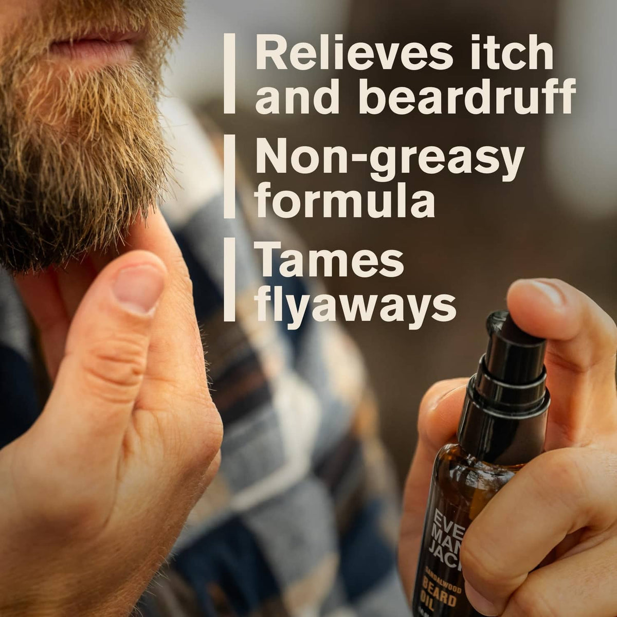 Beard oil bottle with pump held in hand beside trimmed facial hair