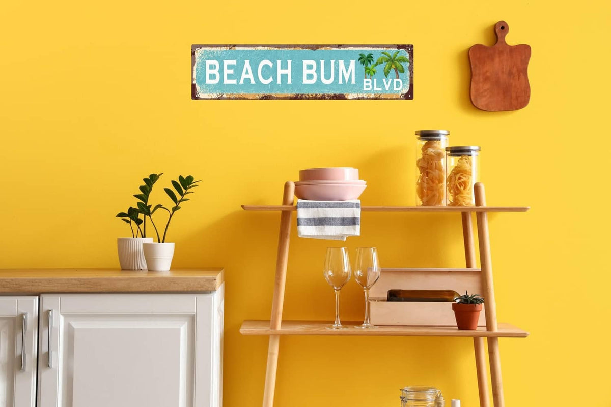Small vintage tin sign reading “BEACH BUM BLVD” with palm tree graphic