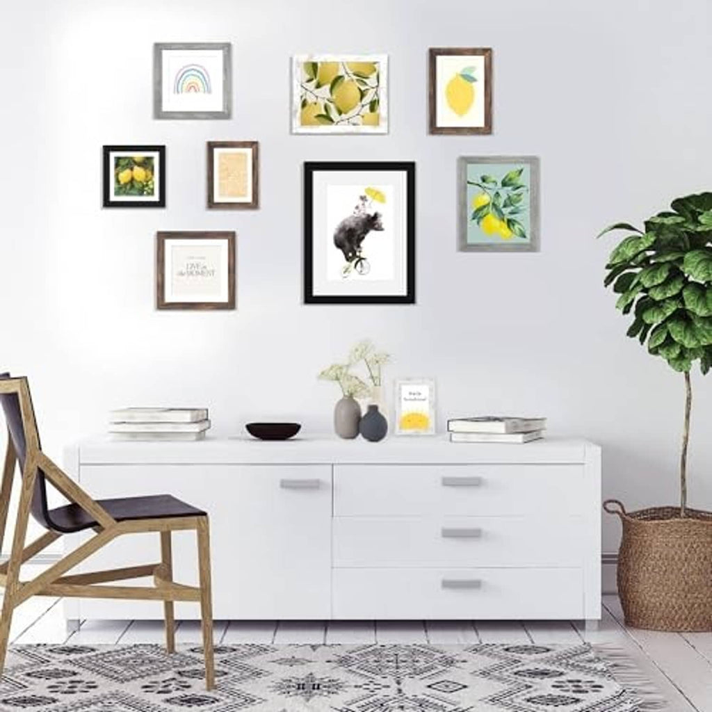 Black and wood picture frames wall display with multiple small framed photos