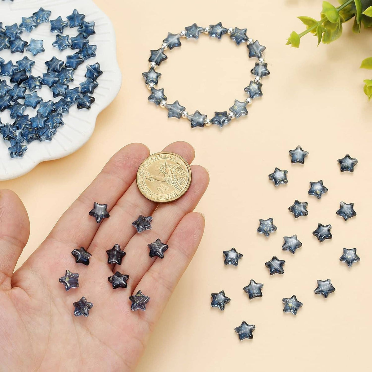 Blue star glass spacer beads held in a hand with loose beads nearby