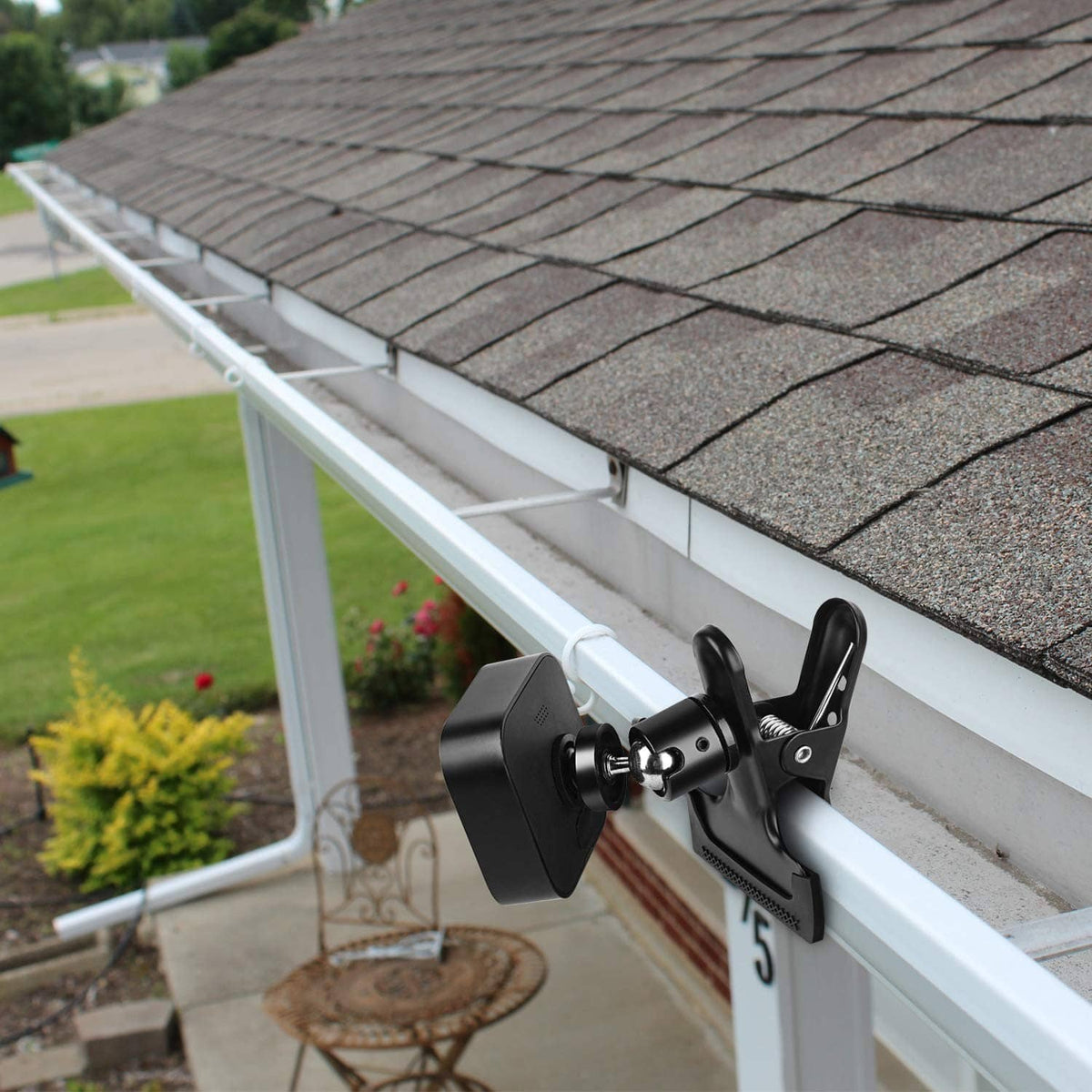 Black clip clamp mount holding a camera on a porch railing
