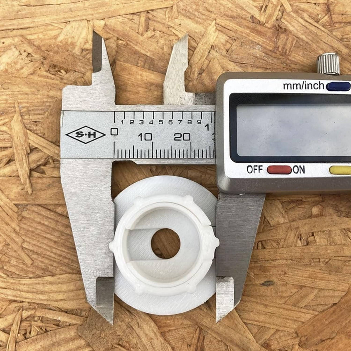 White grommet ring measured with caliper; wall pass-through insert