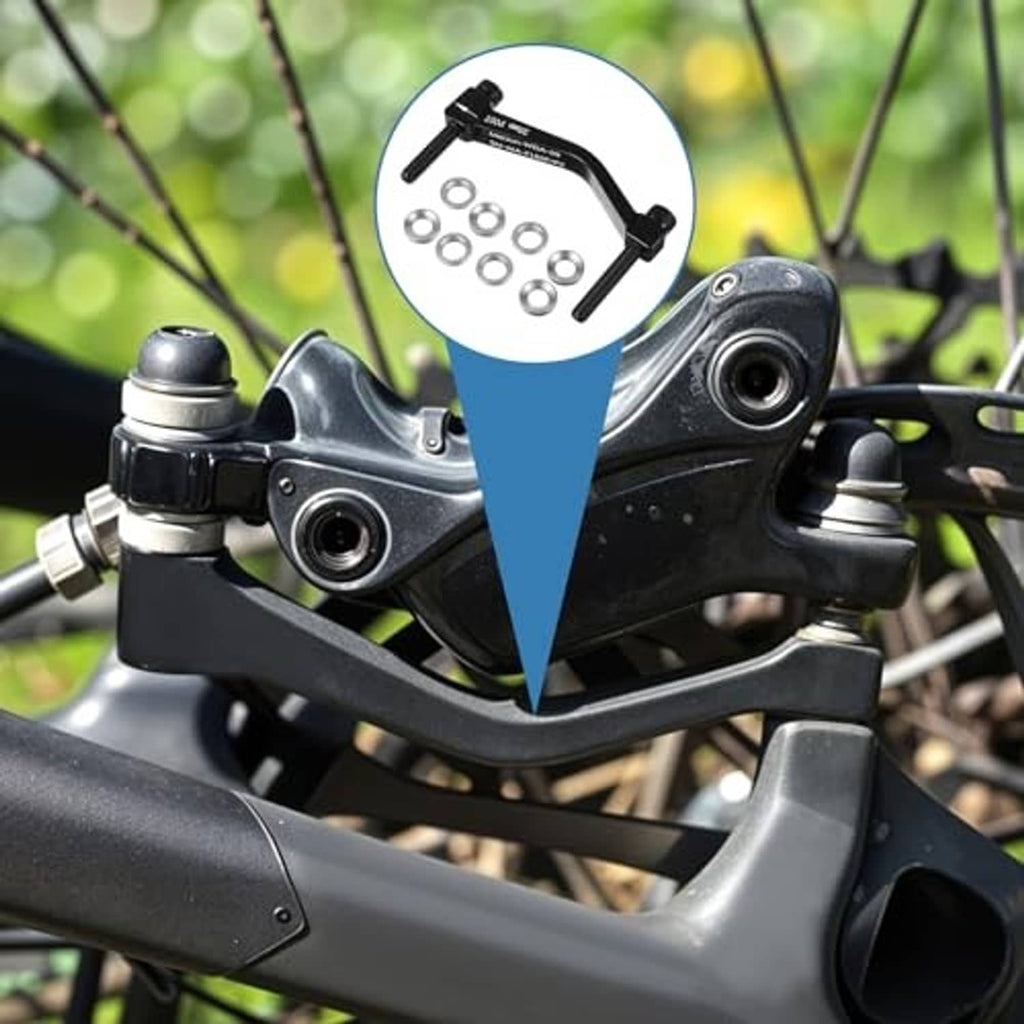 Disc brake caliper mount adapter shown mounted on bike, black bracket and hardware