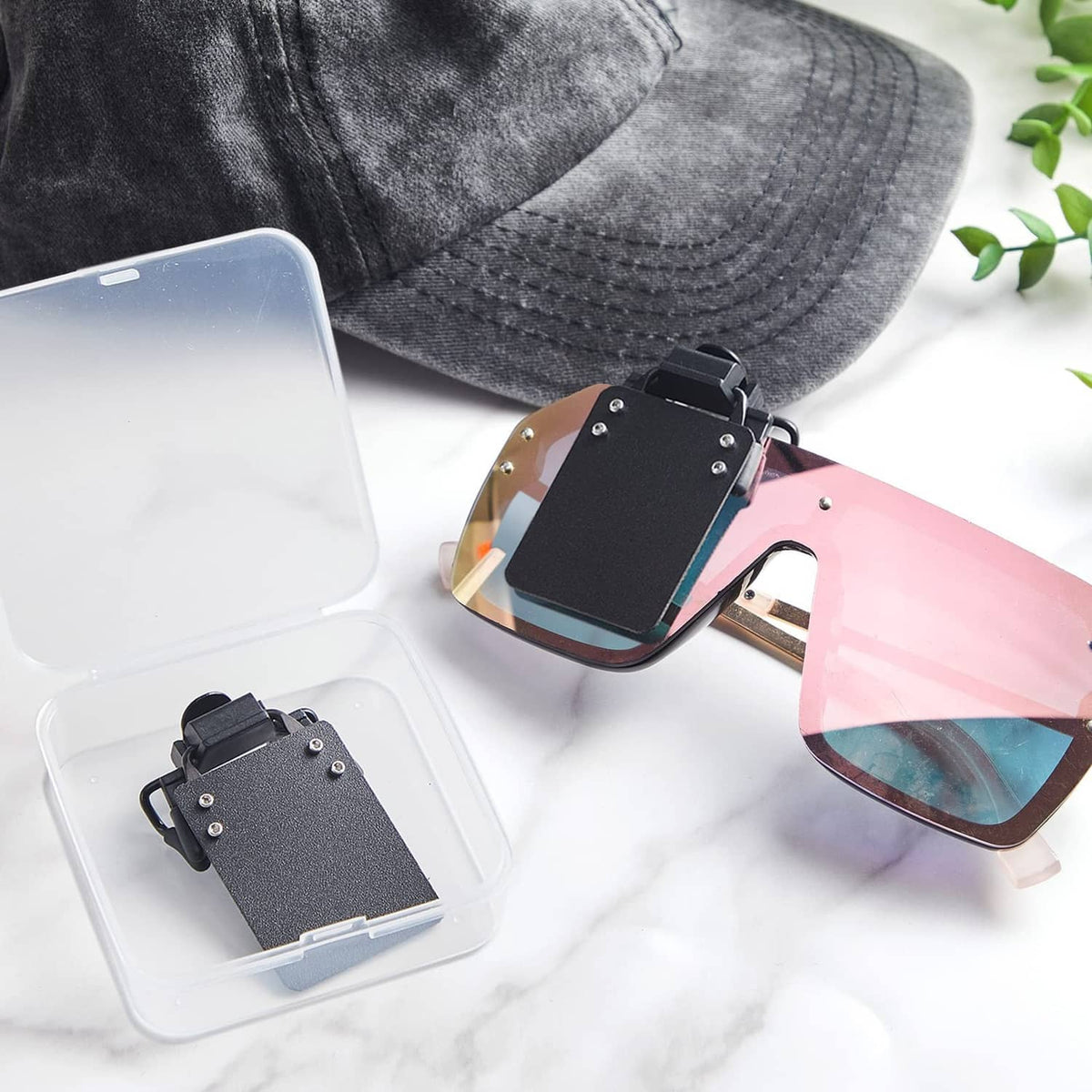 Black clip-on shooting glasses patch with adjustable clip, in clear storage box