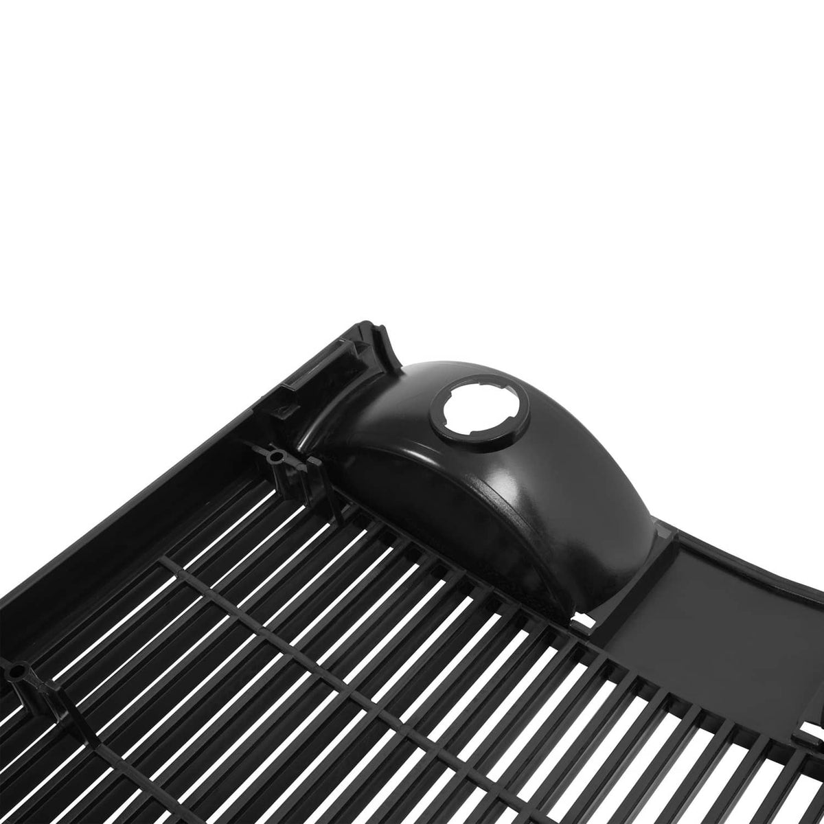 Tractor grille top corner with black plastic cover and circular opening over slat guard