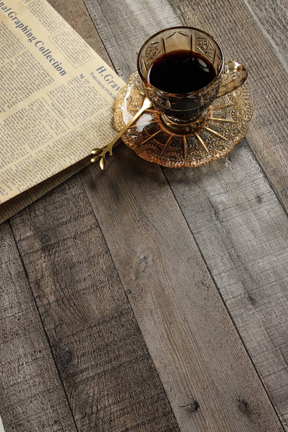 Gray wood-plank peel-and-stick wallpaper close-up on tabletop with cup and tray