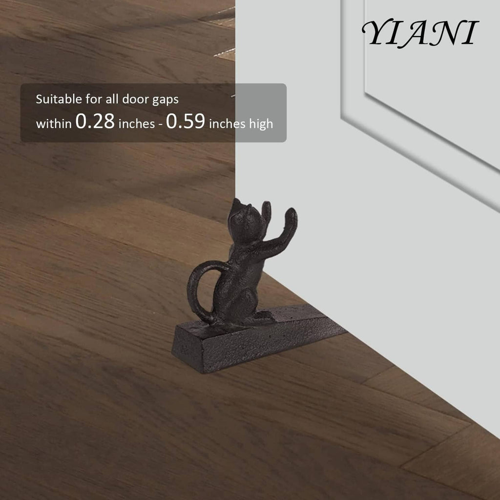 Cast iron cat door stopper positioned at a door gap on wooden floor