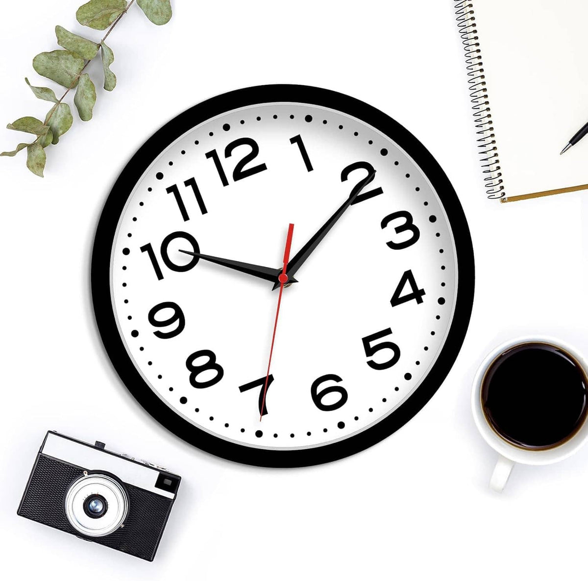 Black-framed wall clock with white dial, large numerals, dotted markers, and red second hand