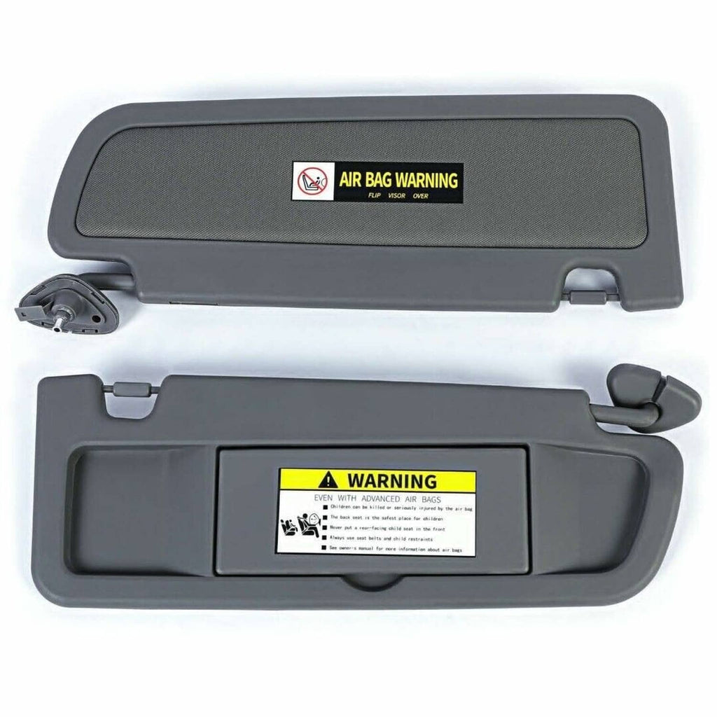 Dark gray sun visor pair with air bag warning labels and flip hinges
