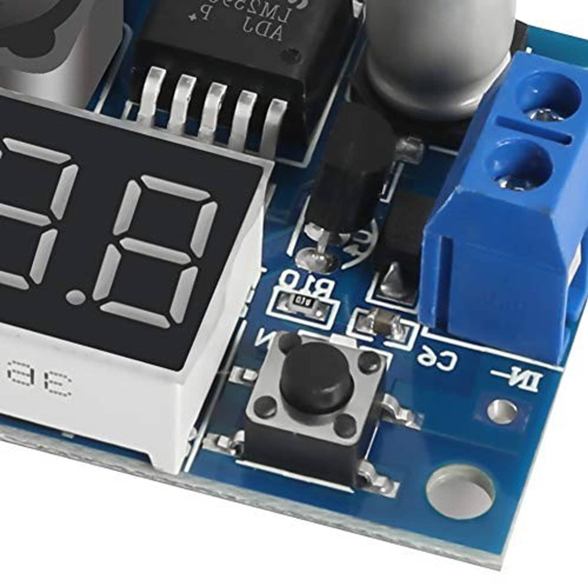 Close-up of LM2596 buck converter with red 3-digit display, control button, and blue OUT terminal
