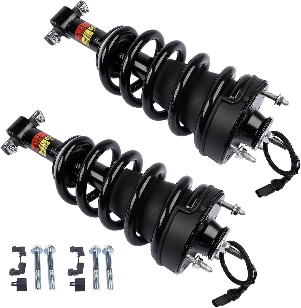 Two black front shock struts with coil springs and warning decals, angled view