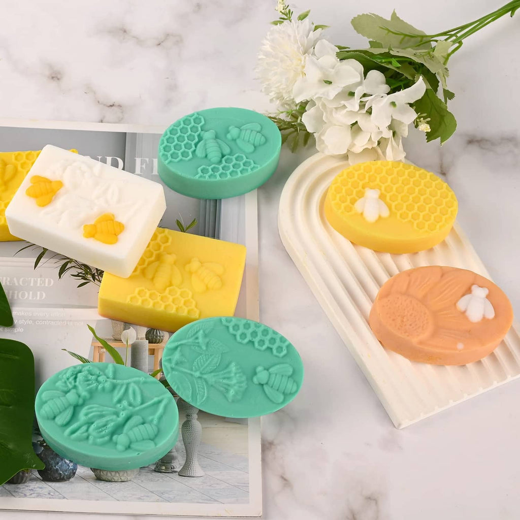 Assorted honeycomb bee silicone soap molds in yellow, orange, green, and white oval shapes