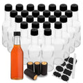 Set of clear glass hot sauce bottles with black caps and dropper accessory pieces