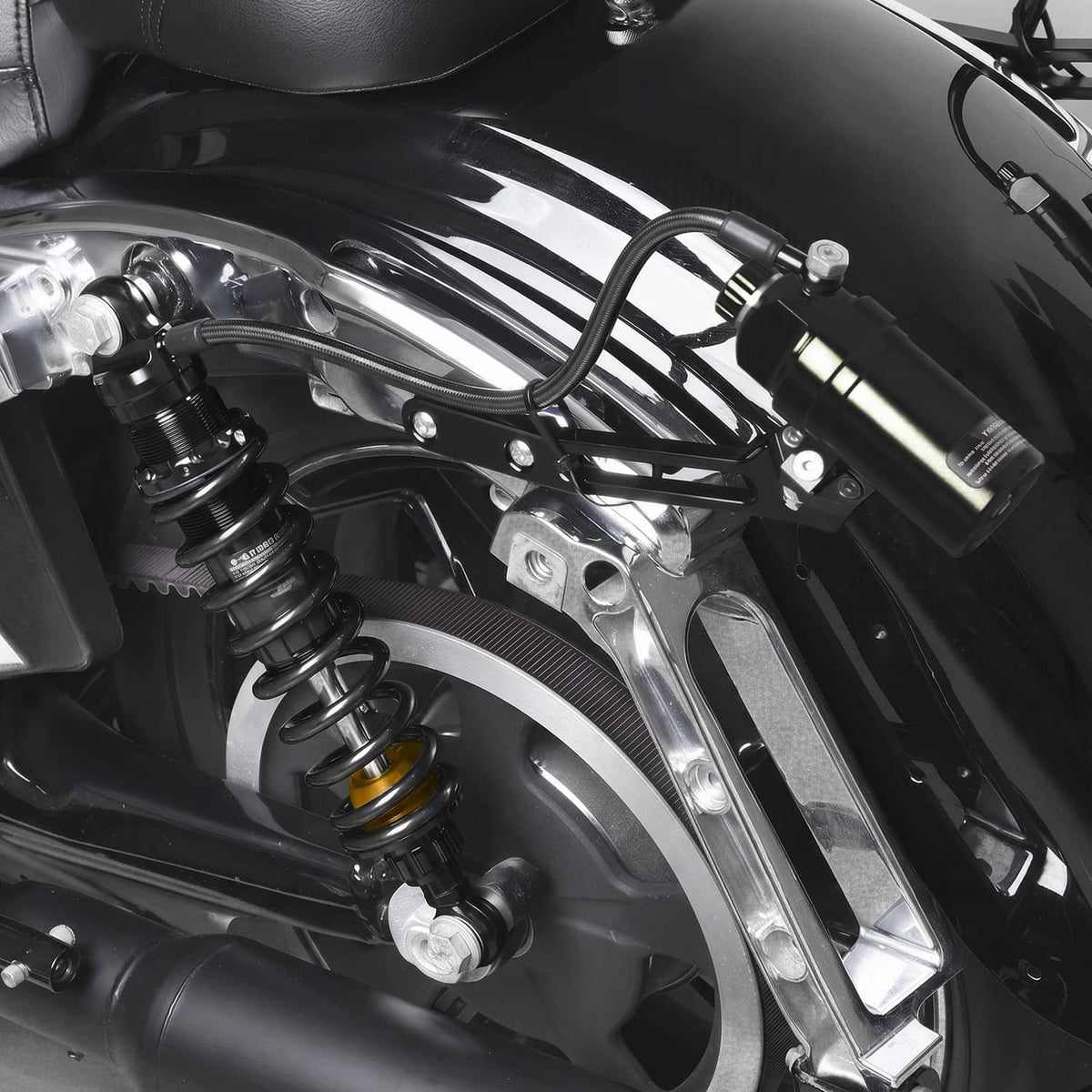 Black remote reservoir suspension shock with spring and mounting bracket on motorcycle