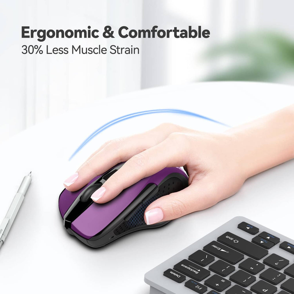 Purple and black ergonomic optical wireless mouse in hand on keyboard