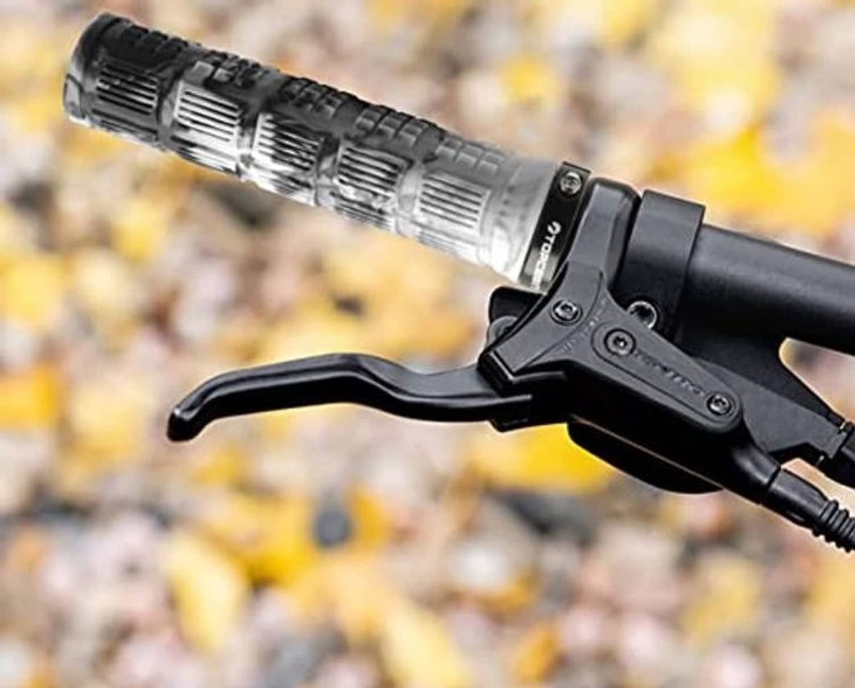 Camouflage bicycle handlebar grip mounted near brake lever, with textured rubber pattern