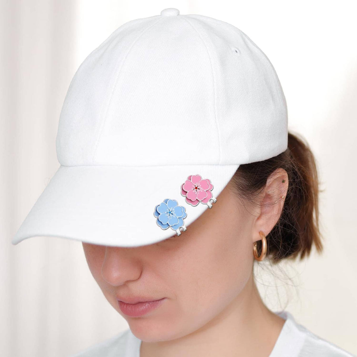 White baseball cap with blue and pink flower magnetic hat clip