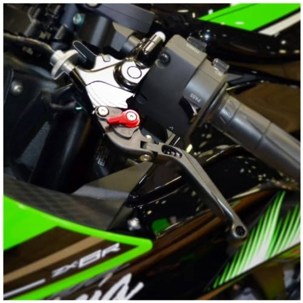 Adjustable folding brake lever on green motorcycle cockpit, black lever with pivot mount