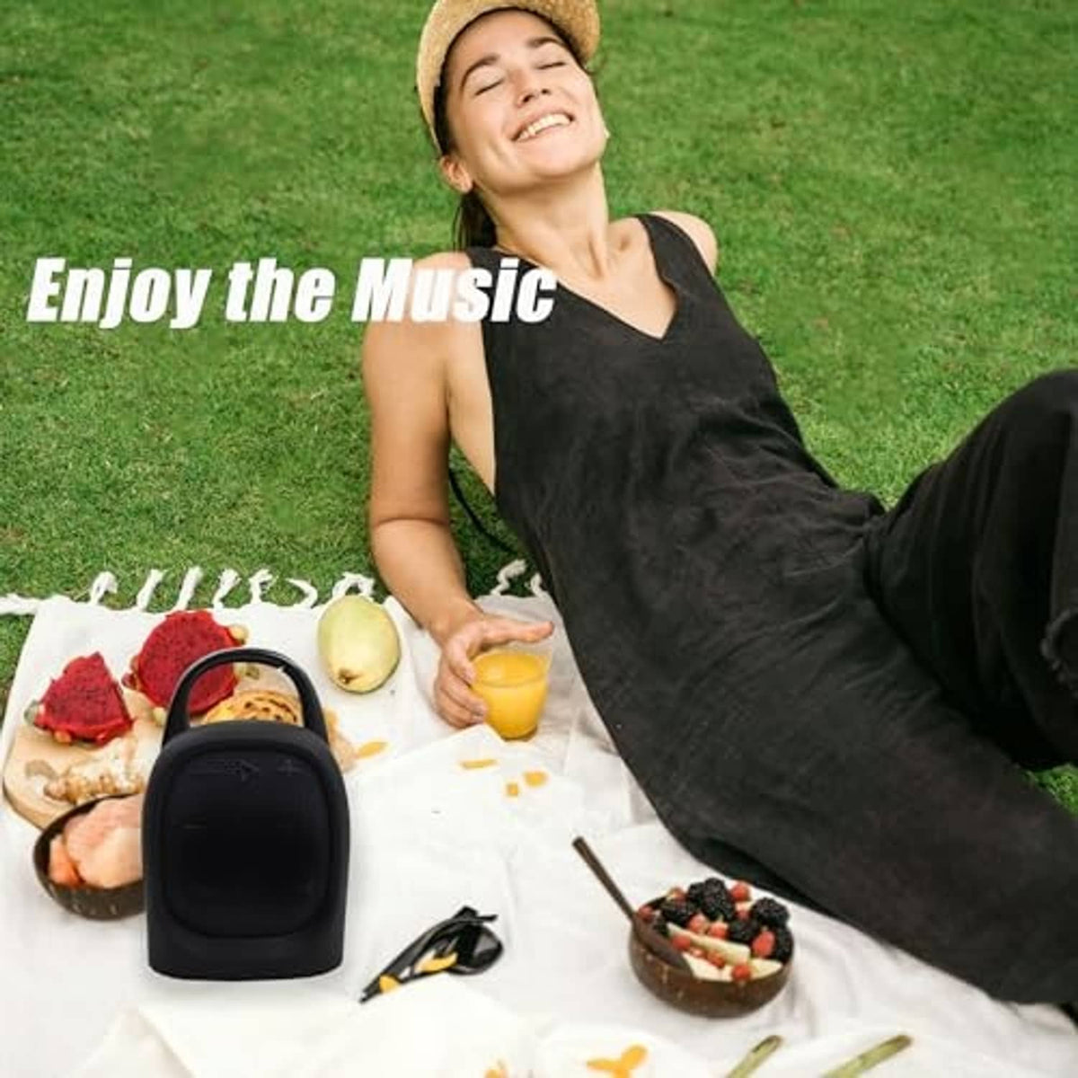 Black silicone speaker cover with carrying handle and strap, placed on a table