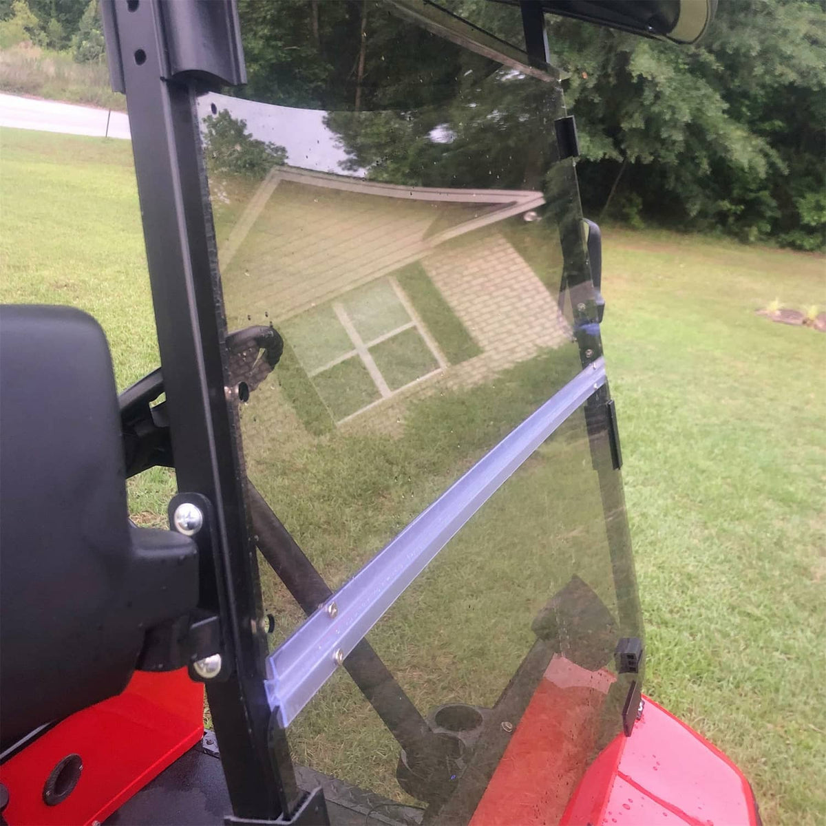 Tinted folding windshield installed on golf cart with side frame and fold seam