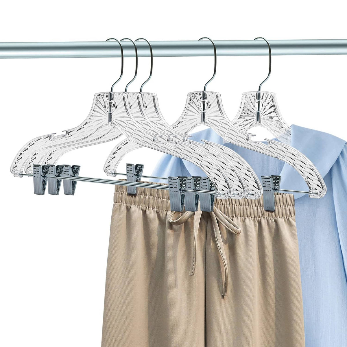 Set of clear skirt hangers with chrome rod bar and cloth clips holding garments