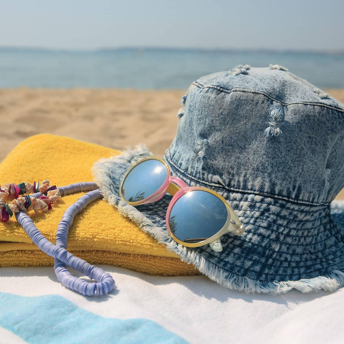 Textile in beach scene with denim bucket hat and sunglasses