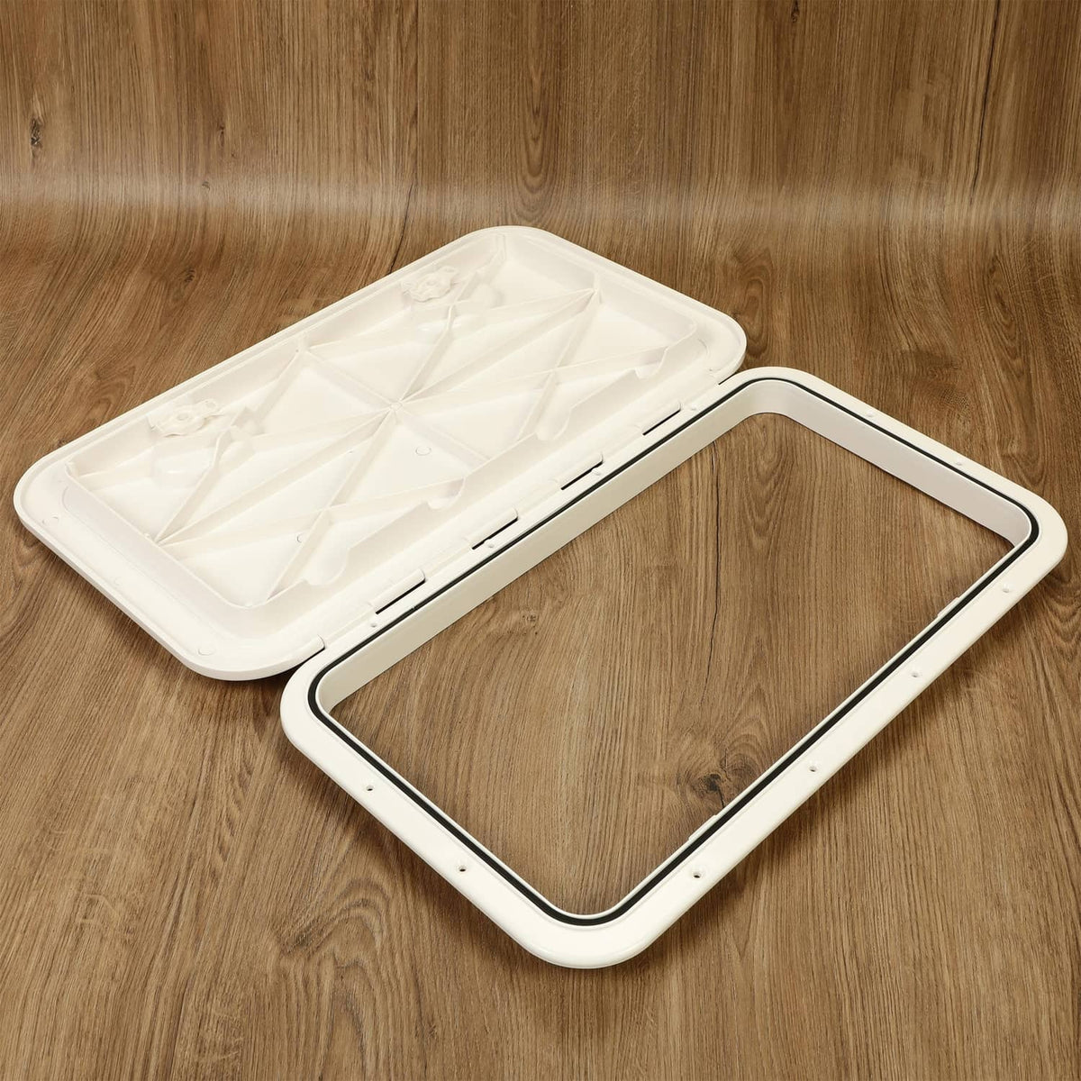 White marine hatch lid partially open revealing inner molded panel and frame