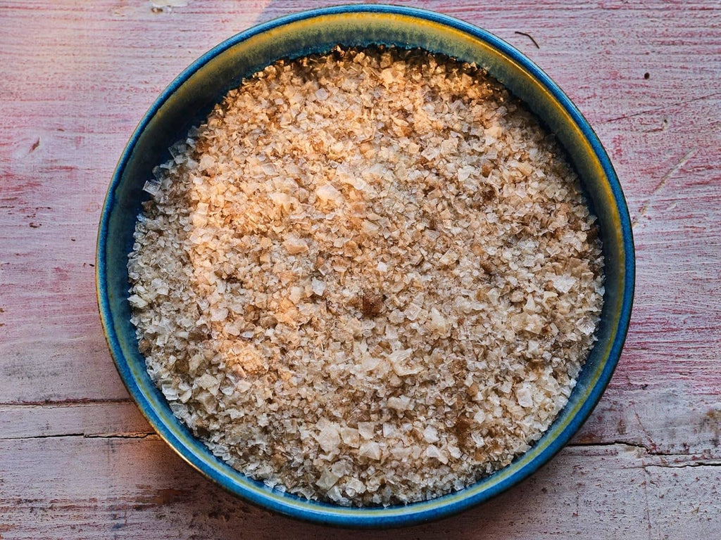 Smoked sea salt flakes in blue-rim bowl