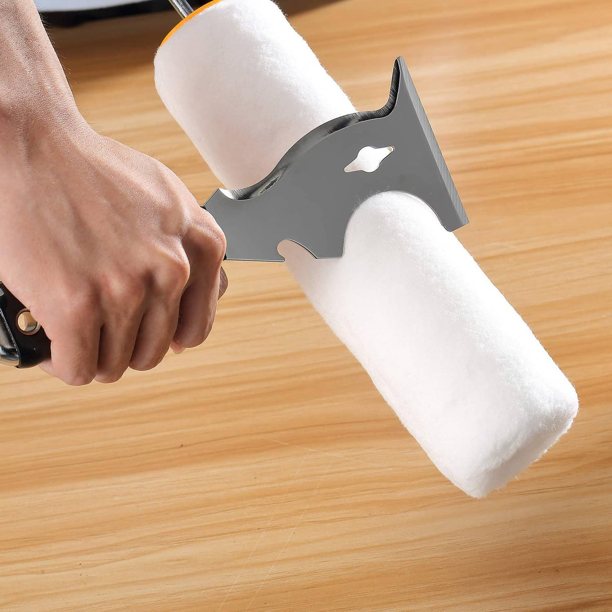 Paint scraper blade used on a paint roller, with black handle