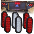 Oval LED trailer tail lights set with red lenses and one white oval lamp, black housings.