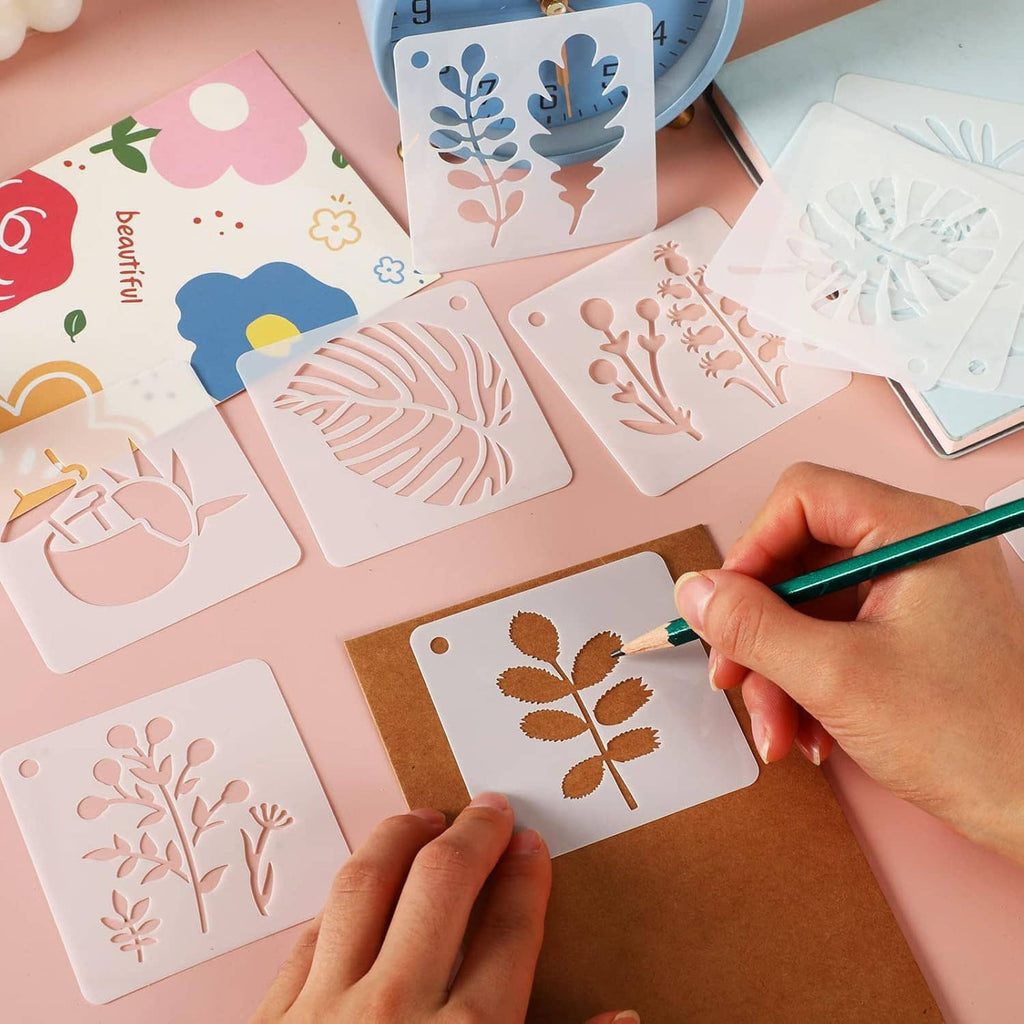 Unpainted flower and leaf stencils with a marker being used on one sheet