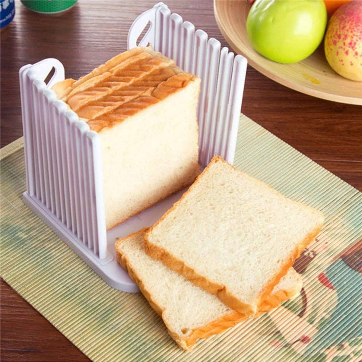 Plastic toast slicer holding a loaf and stacked bread slices on a base