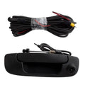 Backup tailgate handle camera with black housing, lens at corner, wiring harness shown