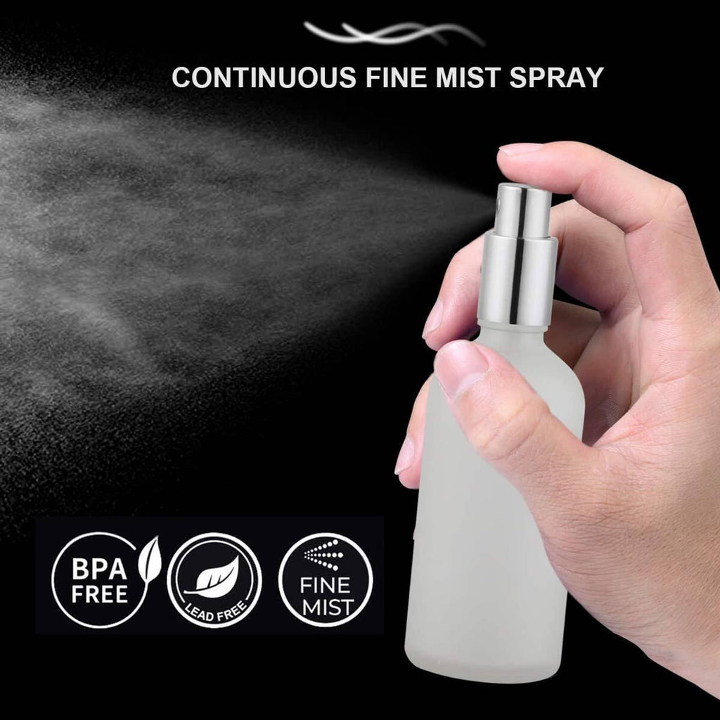 Frosted glass spray bottle with silver nozzle producing continuous fine mist
