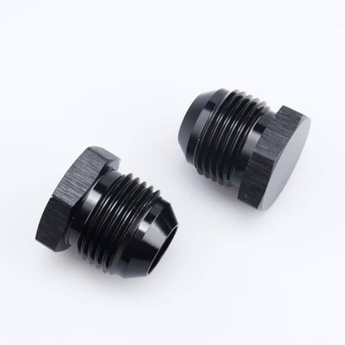 Black AN male flare blanking plug connectors close-up, showing threads and hex rims