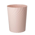 Light pink plastic trash can with ribbed sides and open top