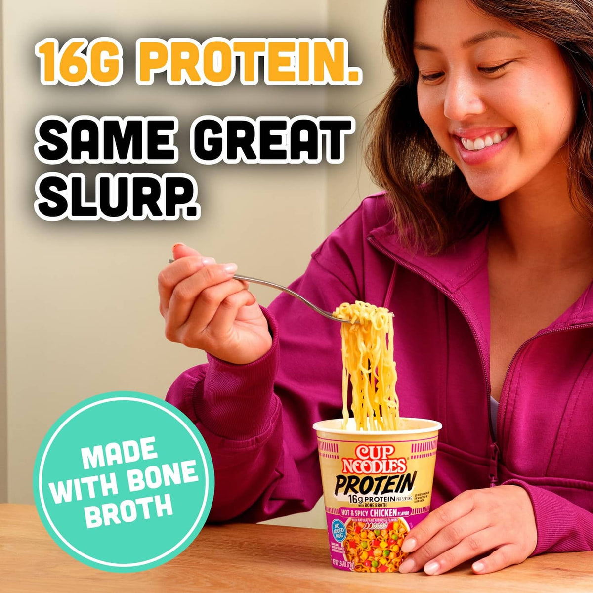 Cup Noodles Protein hot ramen cup beside smiling person holding chopsticks