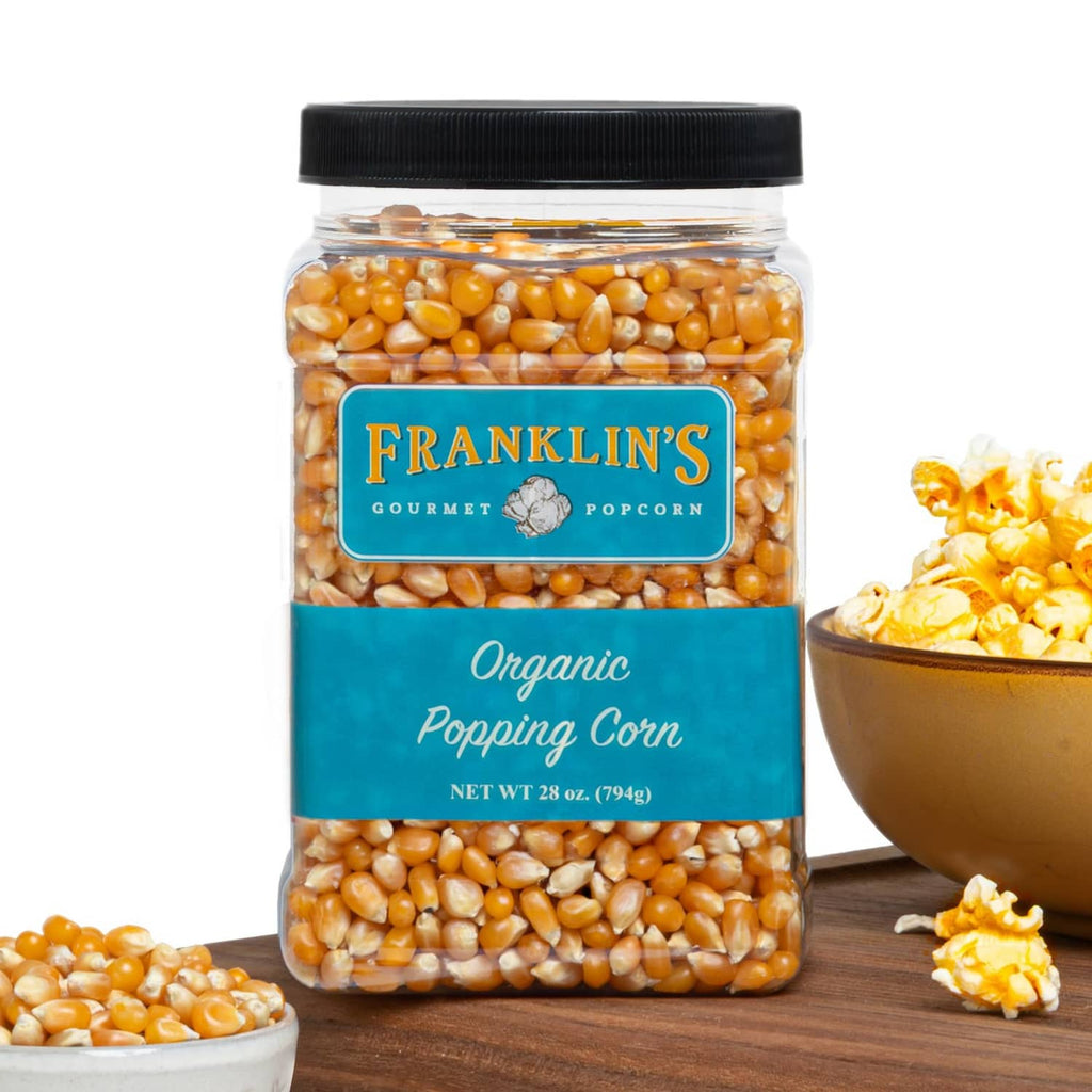 Organic popcorn kernels in clear jar with black lid, Franklin’s Gourmet label.