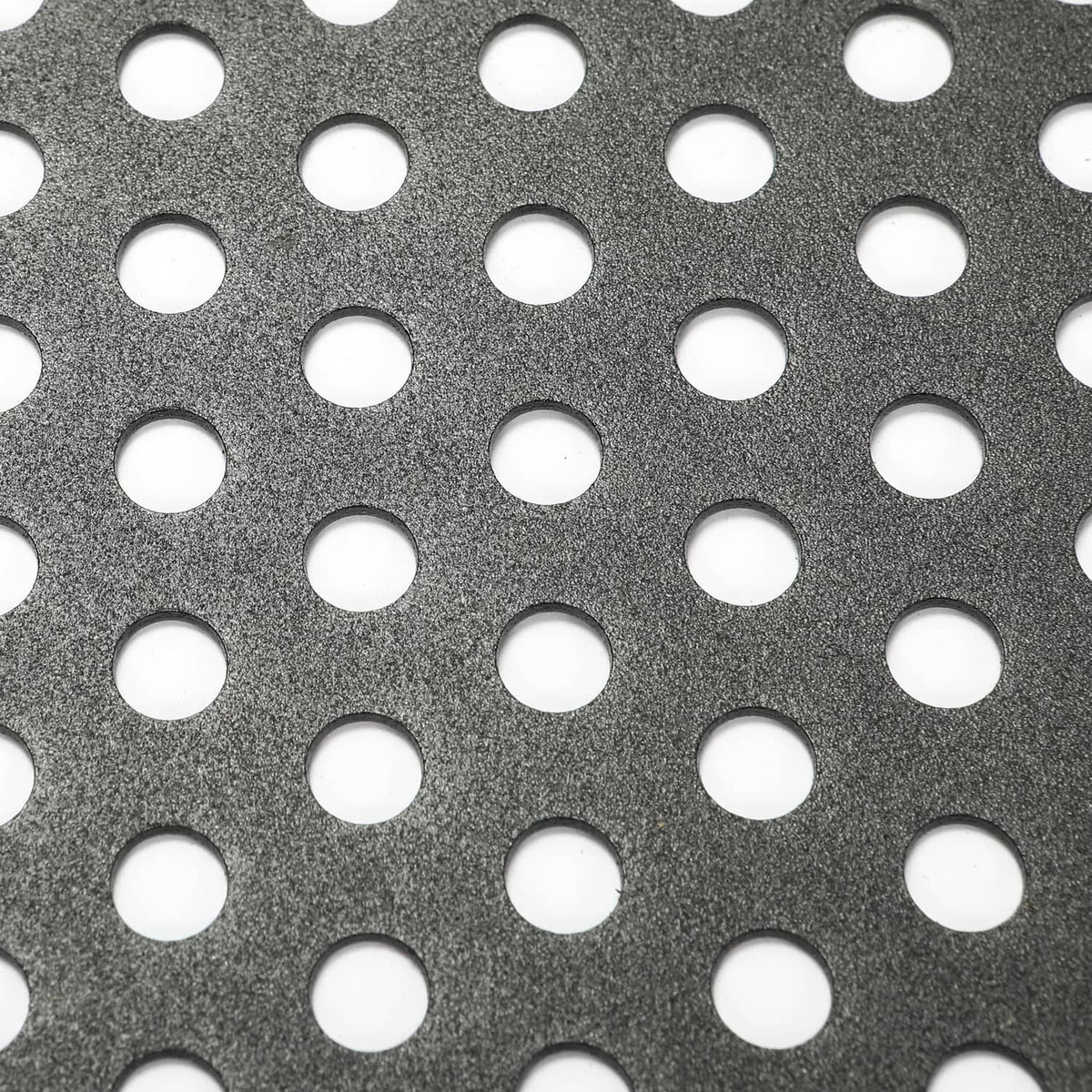 Close-up of perforated metal pattern with round holes in dark finish