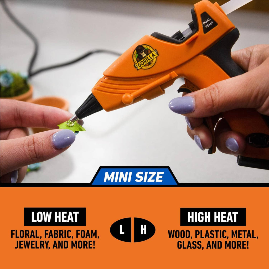 Orange mini hot glue gun applying glue from a precision tip to a small craft piece