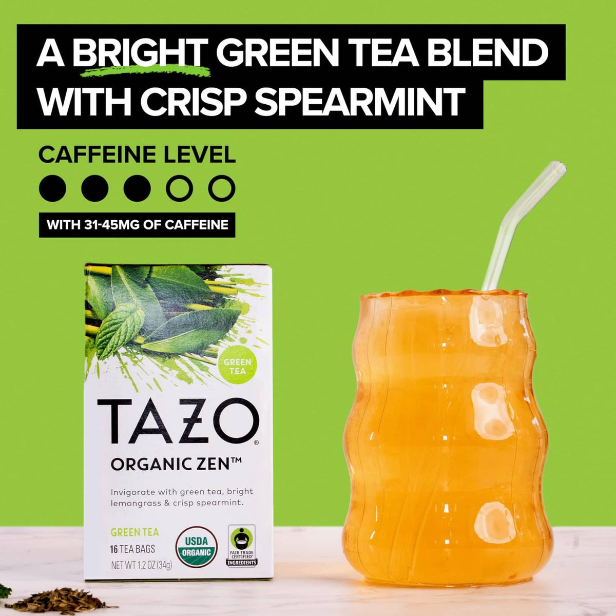 TAZO Organic Zen green tea box with spearmint leaves beside a glass iced drink